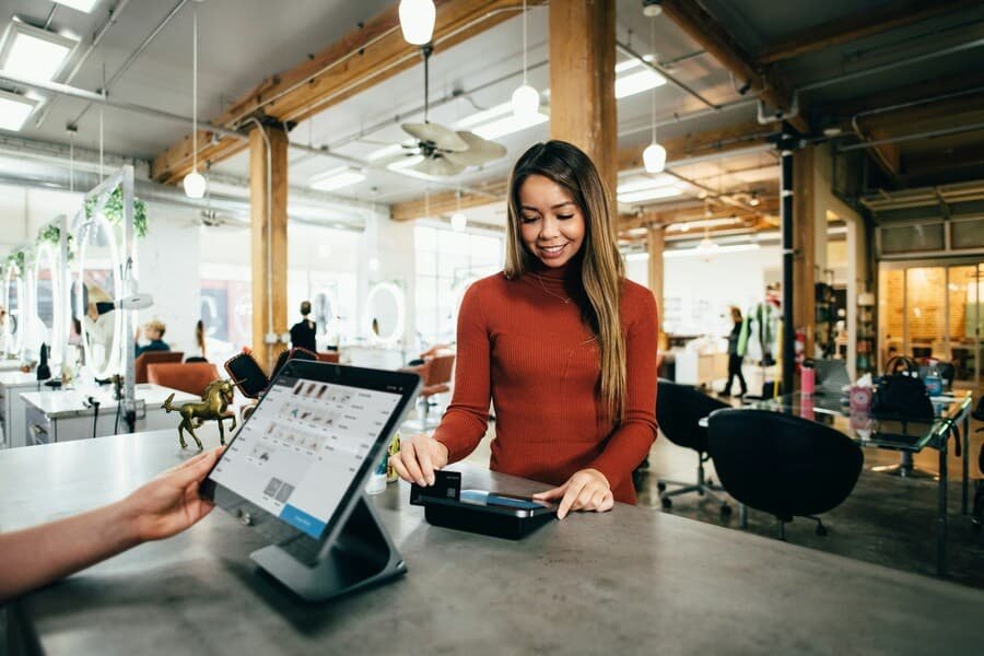 using-credit Woman using a credit card at a payment terminal, symbolizing responsible credit usage and building credit history